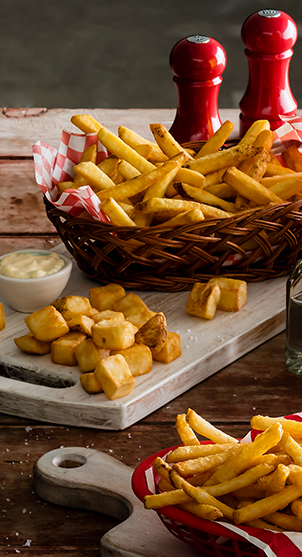 Selection of McCain french fries and fries, and potato cubes. Red salt & pepper pots.