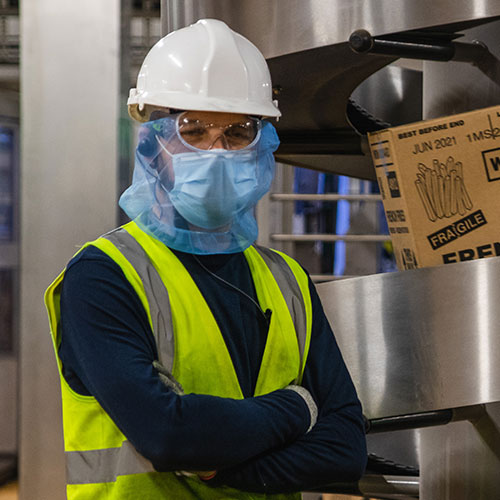 McCain Foods factory team member in factory, wearing a mask