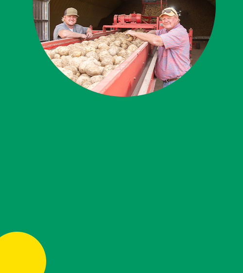 Braden and Rod Lake - two farmers stood with potatoes on farming machinery